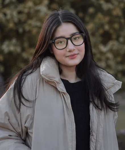 Woman wearing Ainvue frames in a beige coat
